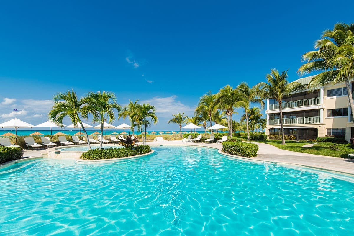 Resort pool surrounded by palms at The Sands at Grace Bay
