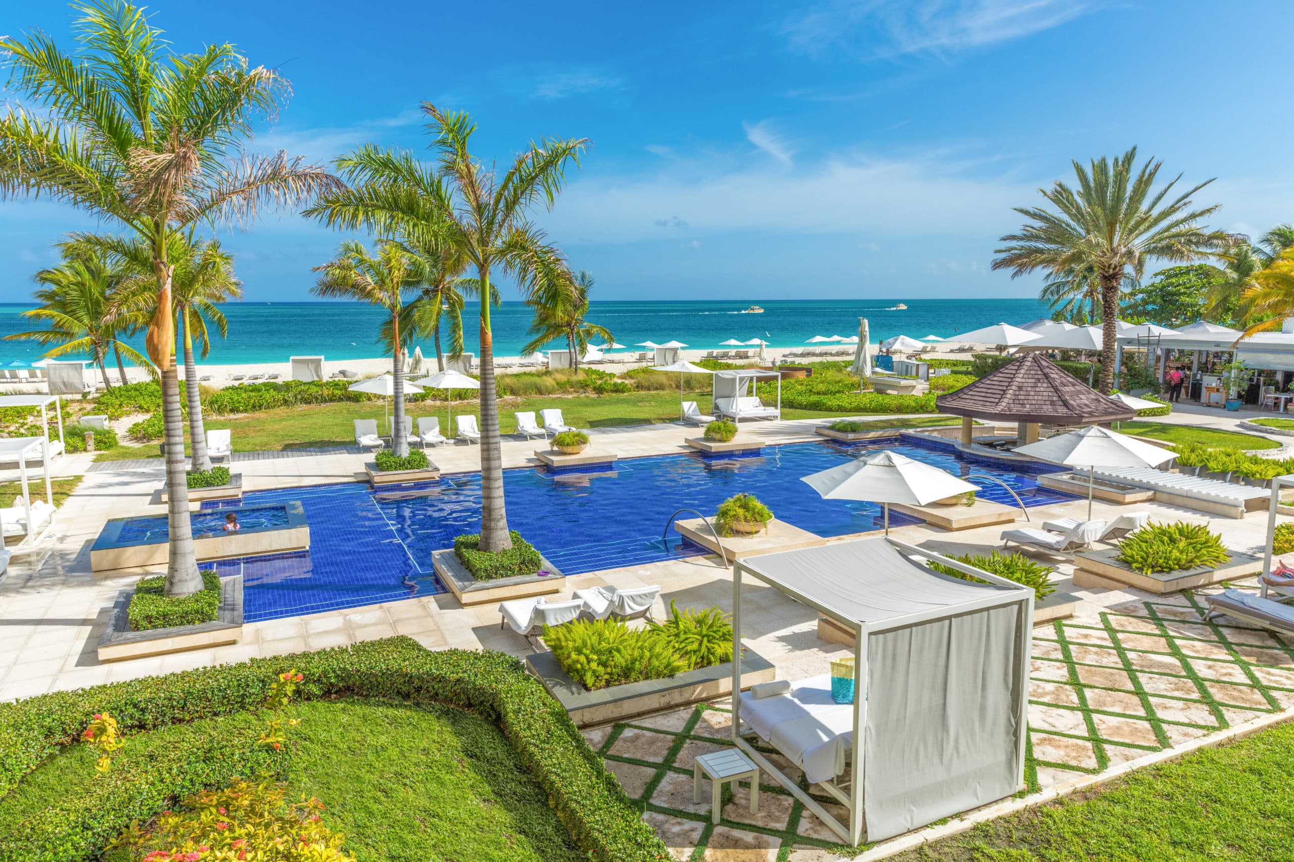 Beachfront pool and lounge area at Grace Bay Club overlooking the turquoise Caribbean sea